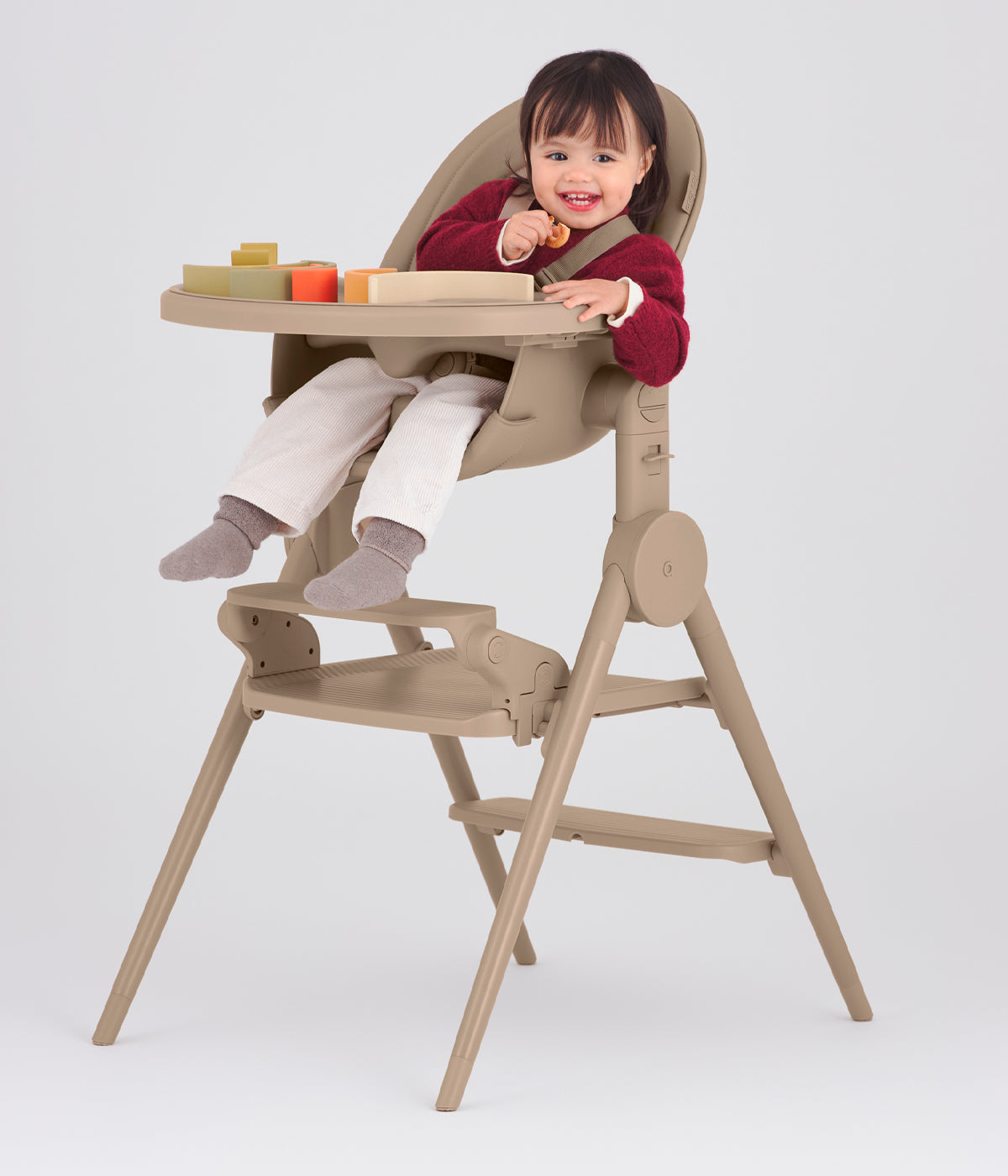 Vista frontal do apoio de pés Anex Ozy Footrest para cadeira evolutiva Ozy na cor Fluff. Prático apoio de pés concebido para proporcionar um suporte estável e confortável aos pés da criança durante a utilização da cadeira evolutiva Anex Ozy.