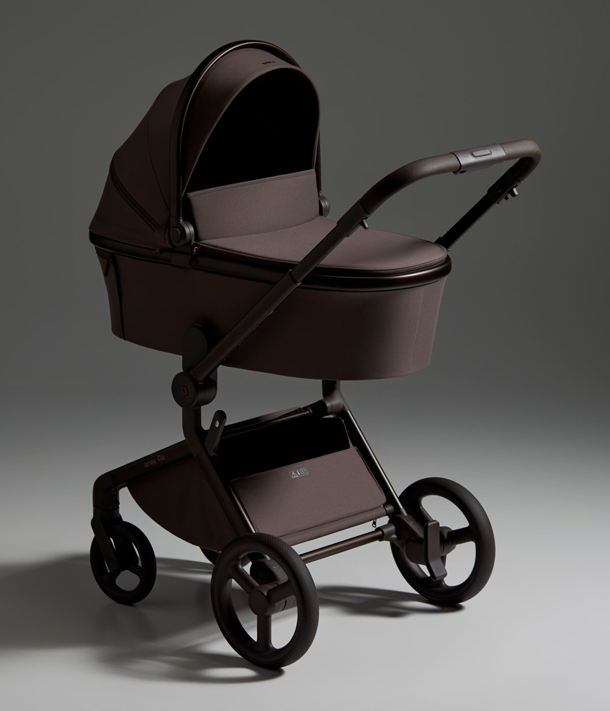 Vista lateral do carrinho de passeio Flo da marca Anex na cor Browny. Elegante carrinho que acompanha o bebé desde o nascimento até aproximadamente aos 4 anos, combinando uma alcofa leve e espaçosa com um assento de passeio reversível até aos 22 kg.