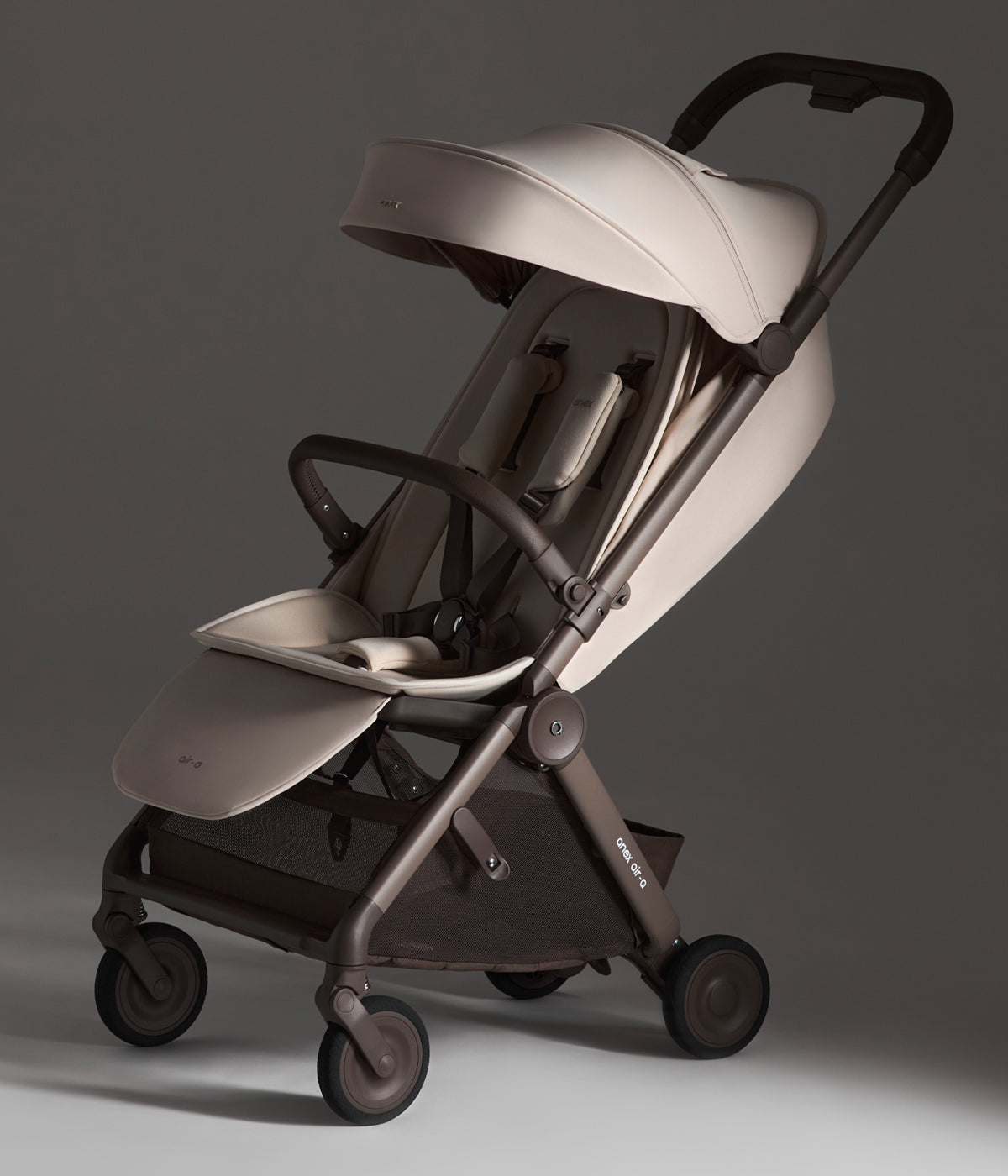 Vista lateral do carrinho de passeio Air-Q da marca Anex na cor Vanille.&nbsp;O Air-Q combina um leve peso com uma dobragem ultracompacta, ideal para as deslocações diárias e viagens.
