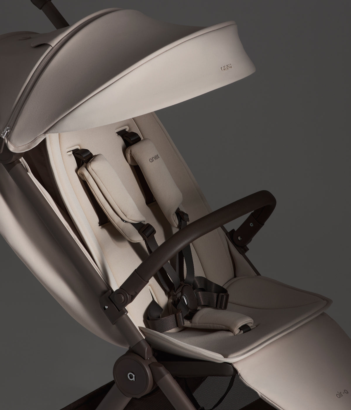 Vista lateral do carrinho de passeio Air-Q da marca Anex na cor Vanille.&nbsp;O Air-Q combina um leve peso com uma dobragem ultracompacta, ideal para as deslocações diárias e viagens.