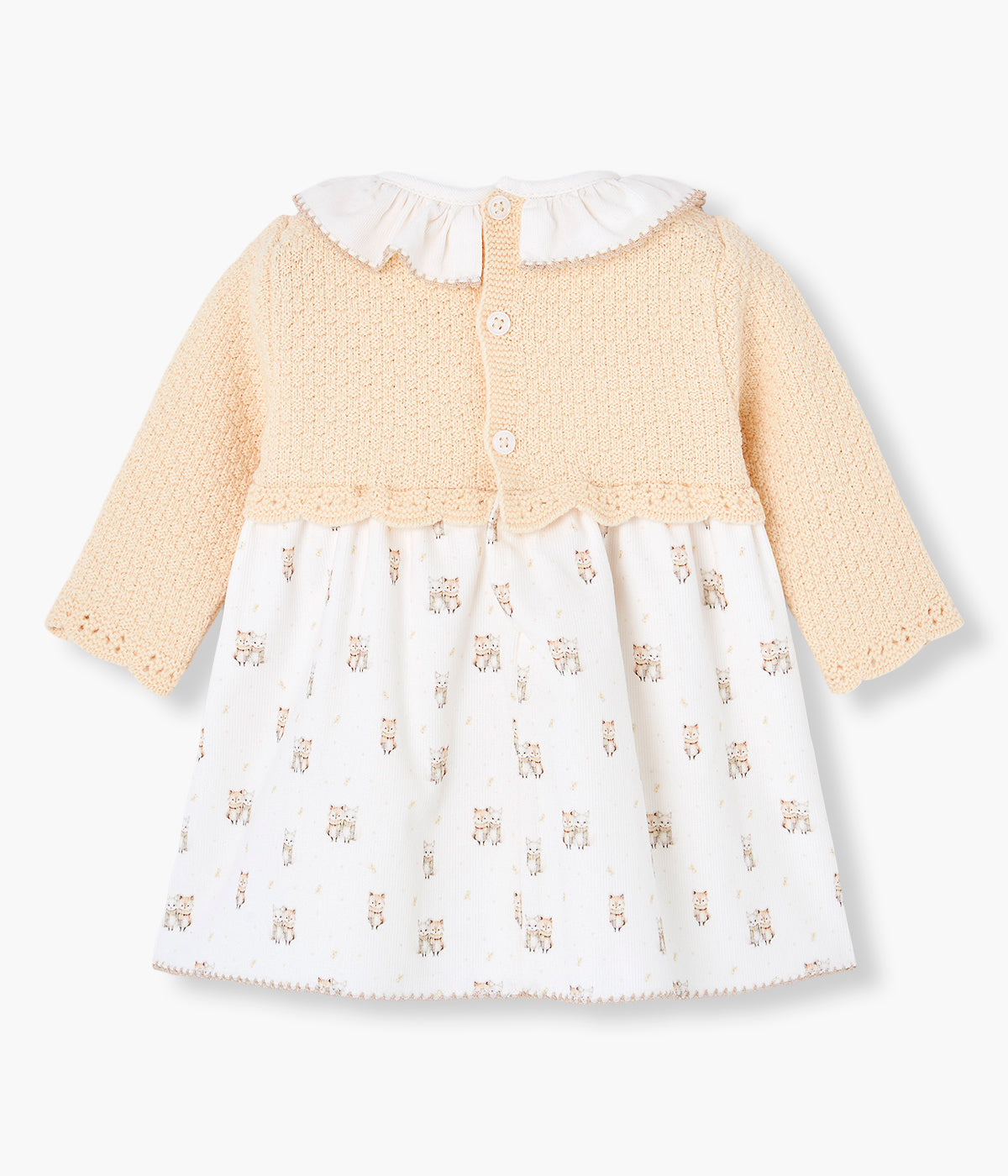 Vista traseira do vestido em malha e algodão da Paz Rodríguez para bebé menina e recém-nascida. Parte superior em malha detalhada em tons de amarelo com gola folho branca com picueta bege. Parte inferior em tecido de algodão branco com padrão gatos. Tapa fraldas a combinar. Abertura nas costas com botões.