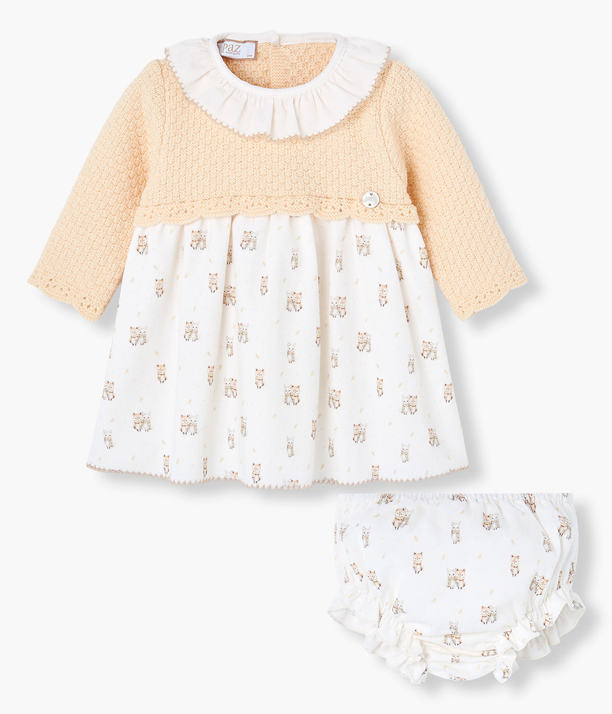 Vestido em malha e algodão da Paz Rodríguez para bebé menina e recém-nascida. Parte superior em malha detalhada em tons de amarelo com gola folho branca com picueta bege. Parte inferior em tecido de algodão branco com padrão gatos. Tapa fraldas a combinar. Abertura nas costas com botões.