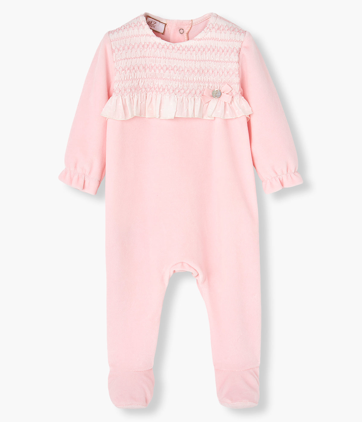 Vista frontal do babygrow em veludo rosa da Paz Rodríguez para bebé menina e recém-nascida. Peitilho em renda com folho em tecido plumeti e laço com medalha madrepérola. Abertura nas costas e entrepernas.
