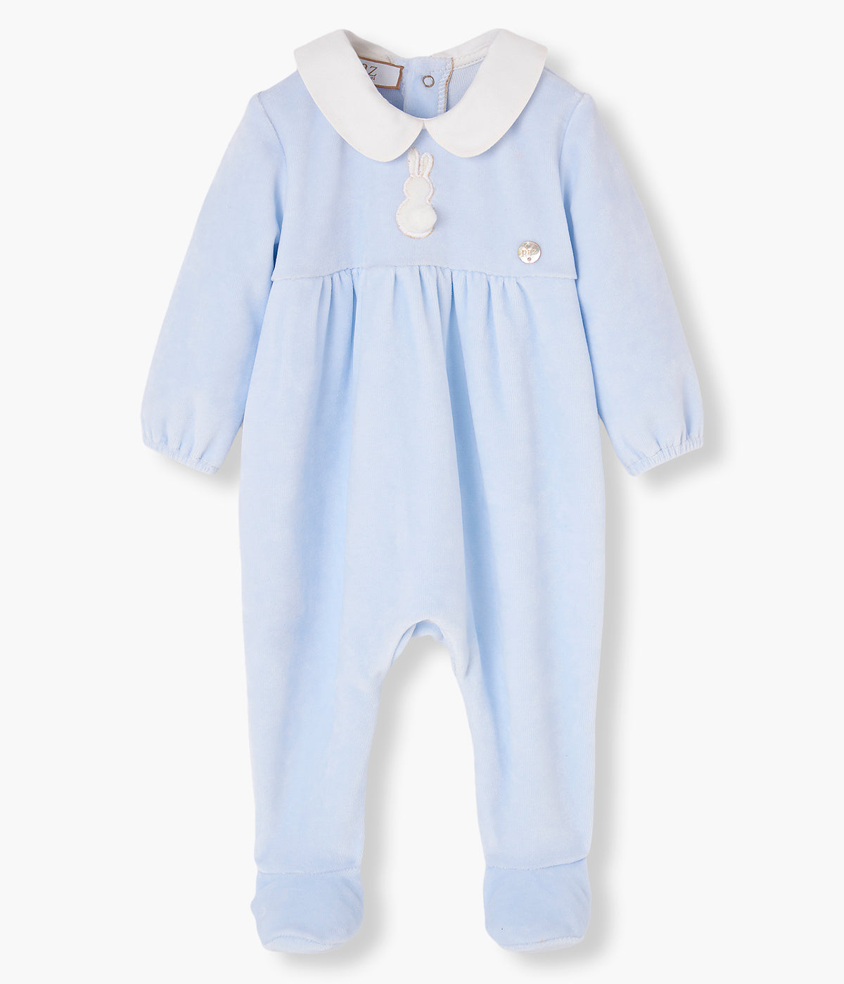 Vista frontal do babygrow em veludo azul da Paz Rodríguez para bebé e recém-nascido(a). Gola redonda cortada em tecido branco. Coelho com pompom na frente. Abertura nas costas.