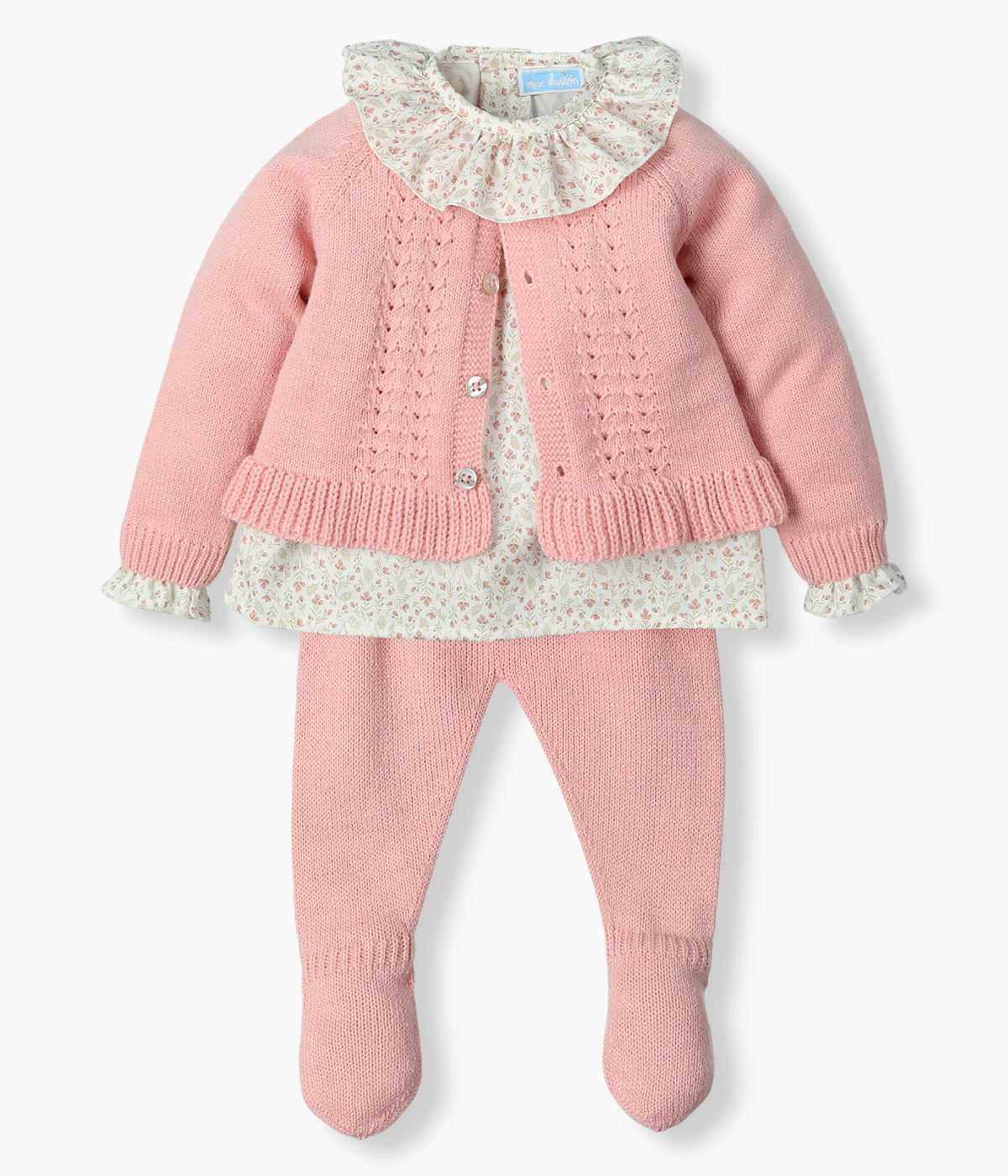 Vista frontal do conjunto de 3pc da Mac Ilusión para bebé menina e recém-nascida. Blusa em algodão pérola com padrão pequenas flores e golha folho. Calças lisas e casaco em malha rosa com detalhes na malha.