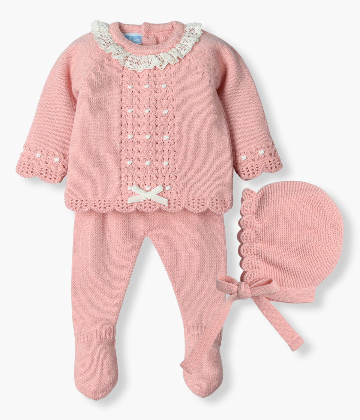 Vista frontal do conjunto de 3pc em malha rosa da Mac Ilusión para bebé menina e recém-nascida. Camisola com gola em renda pérola e detalhes na malha em pérola com laço. Touca com rebordo ondulado. Calças com pés.