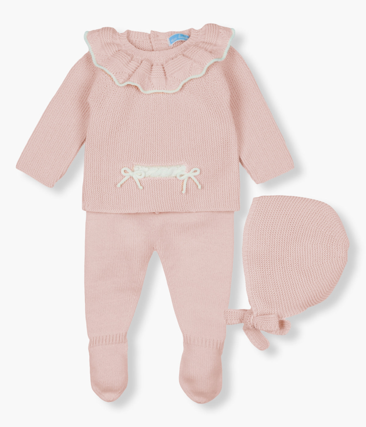 Vista frontal do conjunto de 3pc em malha rosa da Mac Ilusión para bebé menina e recém-nascida. Camisola com gola folho com rebordo branco e detalhe de cordões na frente. Calças lisas com pés. Touca com tiras para atar no queixo.