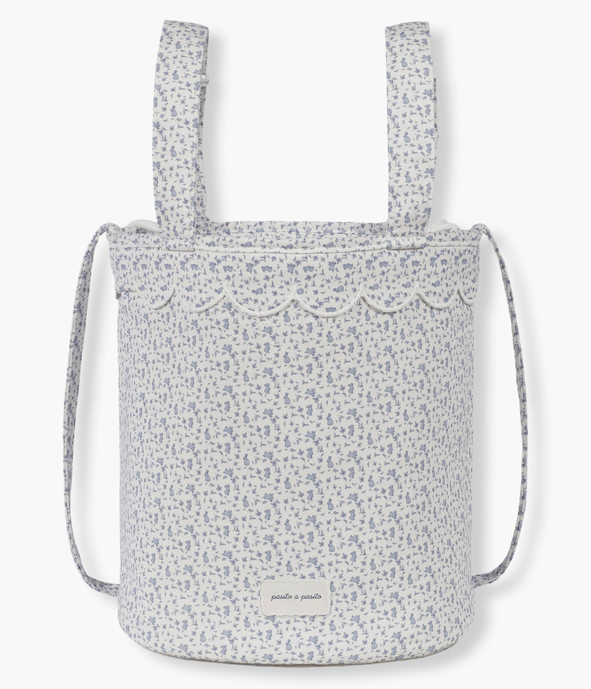 Vista frontal da bolsa bucket Maison Tender da Pasito a Pasito com o padrão Coelhos. Elegante bolsa que combina um formato compacto e funcional com o delicado padrão de coelhinhos da coleção. Fabricada em algodão BCI com tratamento resistente à água, possui forro interior em poliéster, fecho superior por cordão ajustável e espaço para transportar os principais essenciais do bebé. Inclui alças adicionais para prender ao carrinho e uma alça comprida para transportar ao ombro.