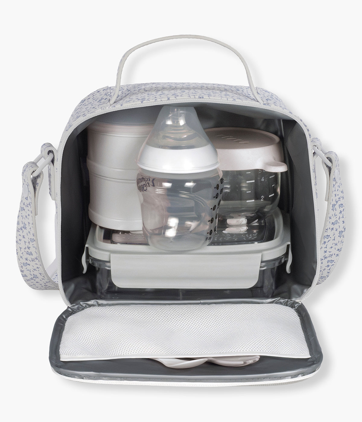 Vista do interior da bolsa térmica Maison Tender da Pasito a Pasito. Prática bolsa que permite transportar a comida e as bebidas do bebé ajudando a conservar a temperatura durante mais tempo. Fabricada em pele vegana com padrão coelhos em tons de azul, possui um interior isotérmico espaçoso, abertura ampla com fecho de correr e um prático bolso de rede na tampa. A pega de mão e a alça de ombro tornam-na fácil de transportar em passeios, viagens, creche ou no dia a dia.