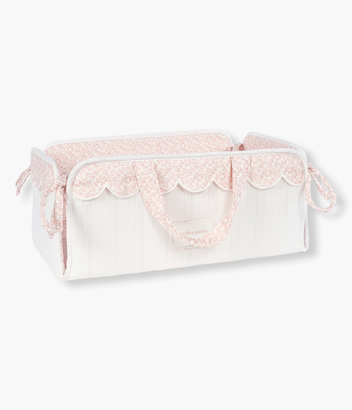 Vista frontal da cesta organizadora Maison Tender da Pasito a Pasito. Elegante cesta que ajuda a manter os essenciais da bebé organizados e sempre à mão. Fabricada em 100% algodão, possui um formato leve e estruturado, ideal para colocar junto ao muda-fraldas, sobre a cómoda ou numa prateleira. O delicado padrão de flores em tons de rosa combina funcionalidade com o estilo suave e elegante da coleção Maison Tender.