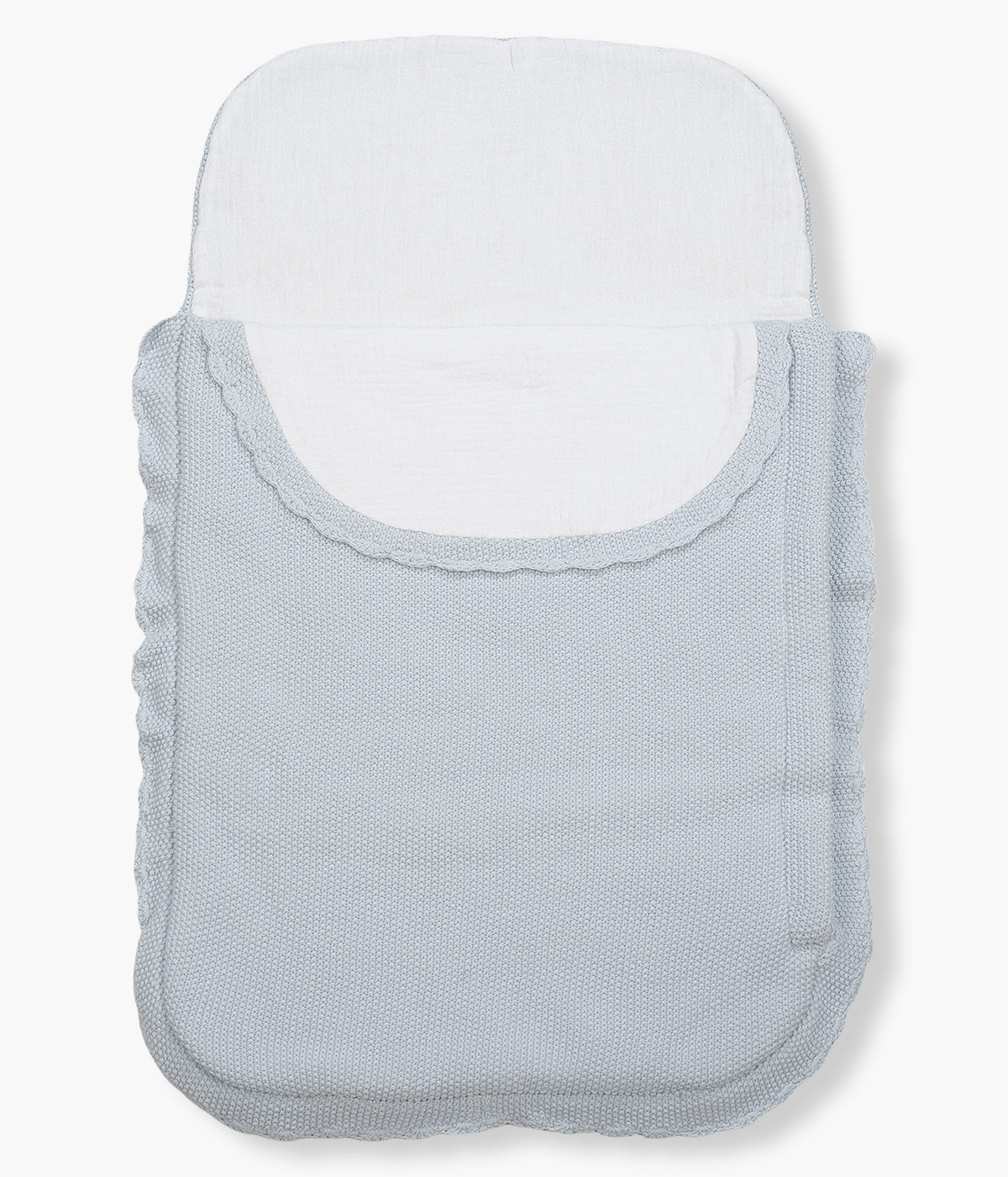 Saco manta em malha de algodão tricot azul da Pasito a Pasito para bebé menino. Este suave saco manta destaca-se pelo seu ponto de arroz requintado e um elegante acabamento com rebordo ondulado. Possui um design funcional com um interior em tecido musselina branco, permitindo ser utilizado como ninho ou como manta de berço, acompanhando o crescimento e as diferentes necessidades do bebé.