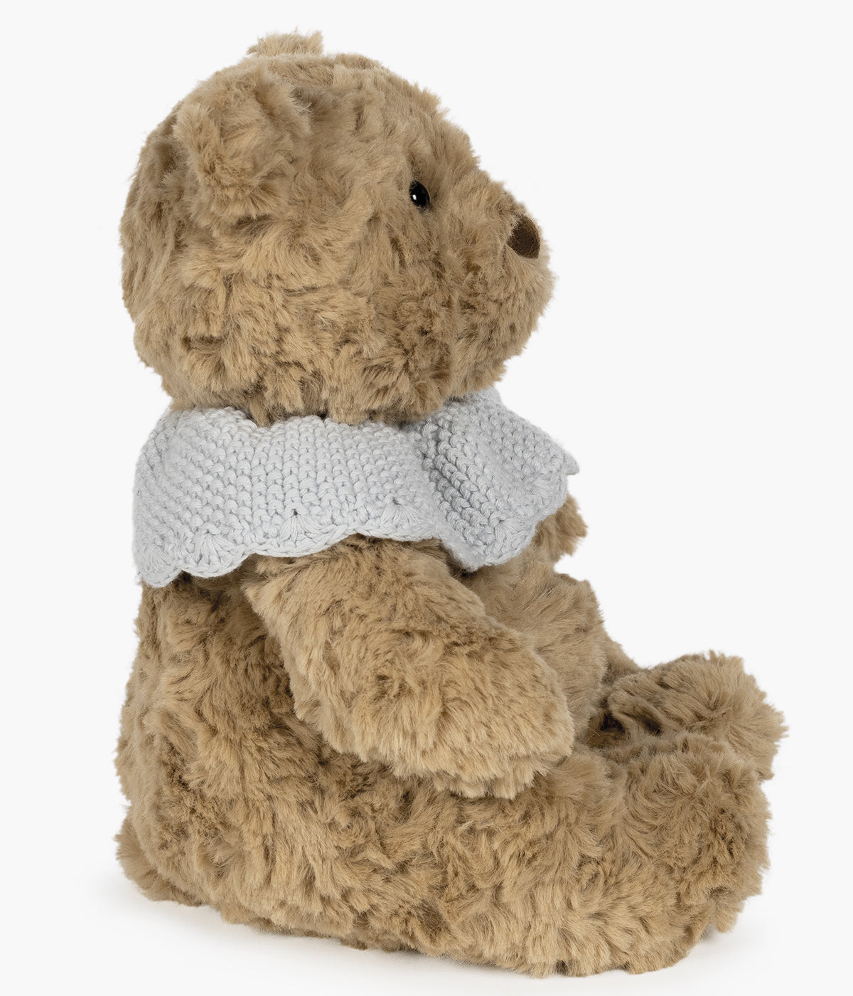 Urso de peluche bege da Pasito a Pasito para bebé menino. Delicado urso com textura aveludada ideal para o contacto com a pele sensível do bebé. O detalhe da gola em tricot, numa tonalidade delicada de azul, confere um toque clássico e amoroso ao seu visual, tornando-o ainda mais especial.