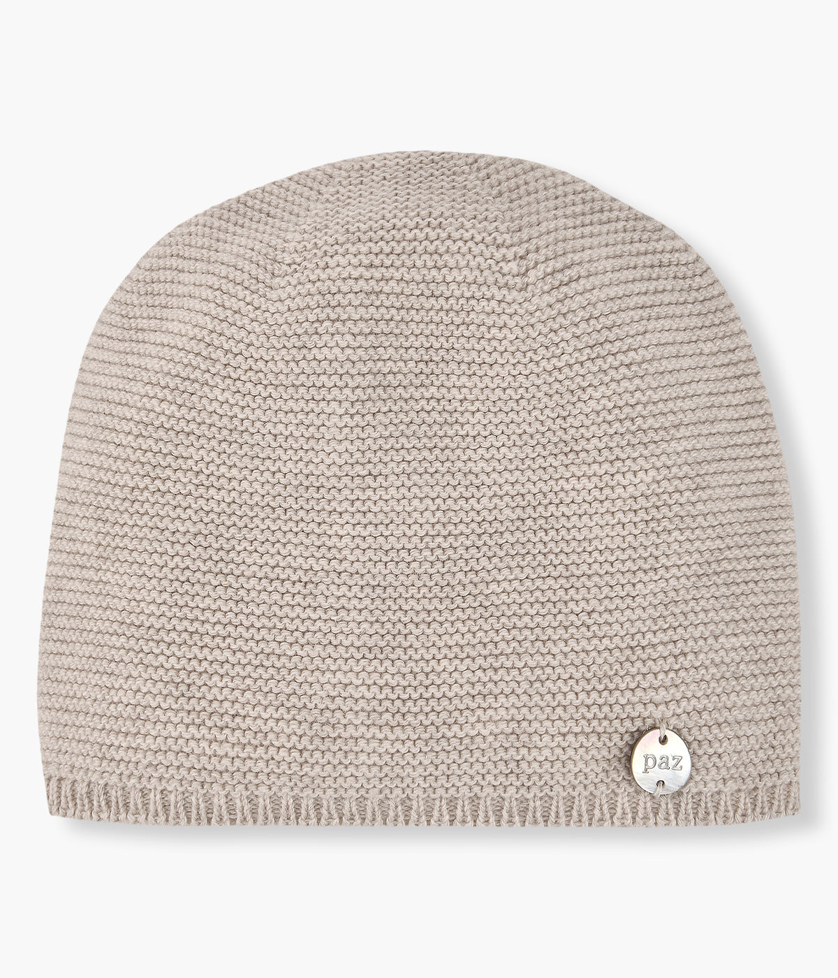 Gorro em malha de algodão com caxemira bege da Paz Rodríguez para bebé e recém-nascido(a). Detalhe de pequena medalha madrepérola com logo da marca.