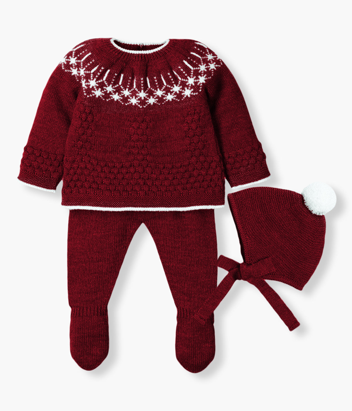 Conjunto de 3 peças em malha bordô da Mac Ilusión composto por camisola, calças e gorro para bebé e recém-nascido(a). Camisola com detalhes em branco. Gorro com pompom branco e tiras para atar no queixo. Calças com pés.