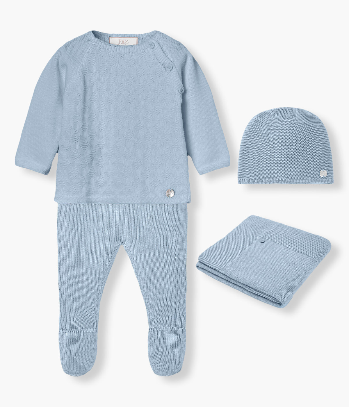 Conjunto de 4 peças em malha de algodão azul da Paz Rodríguez para bebé menino e recém-nascido. Camisola de abertura no ombro com detalhes na malha. Calças lisas com pés. Gorro liso com medalha madrepérola. Manta simples de formato retangular.